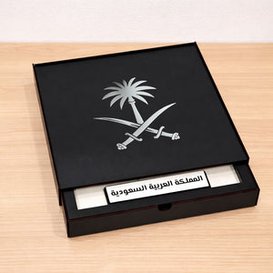 Black box with Saudi Arabia emblem and text on a wooden surface