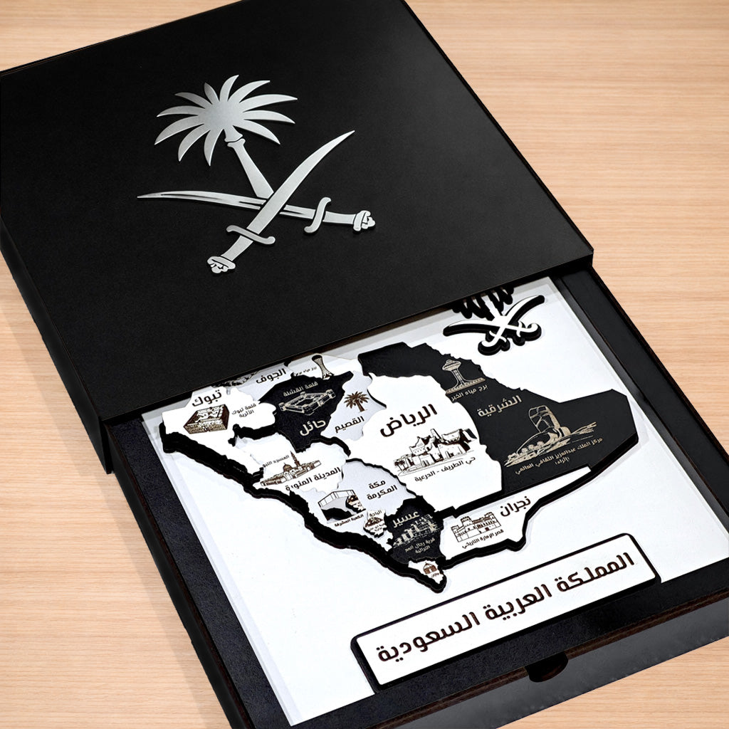 Map of Saudi Arabia with landmarks inside an open black box on a wooden surface