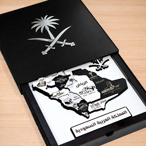 Map of Saudi Arabia with landmarks inside an open black box on a wooden surface
