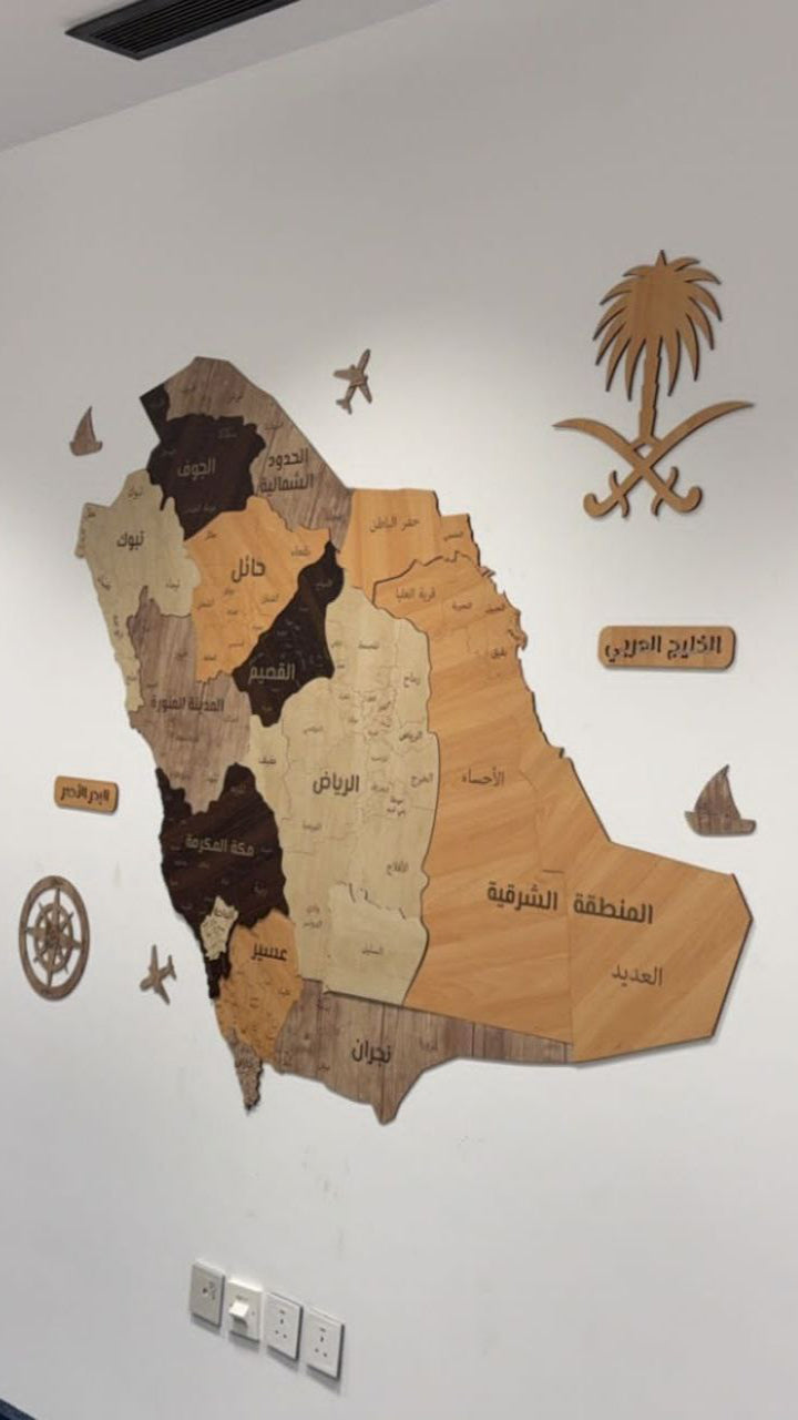 Wooden map of Saudi Arabia on a white wall with decorative elements.